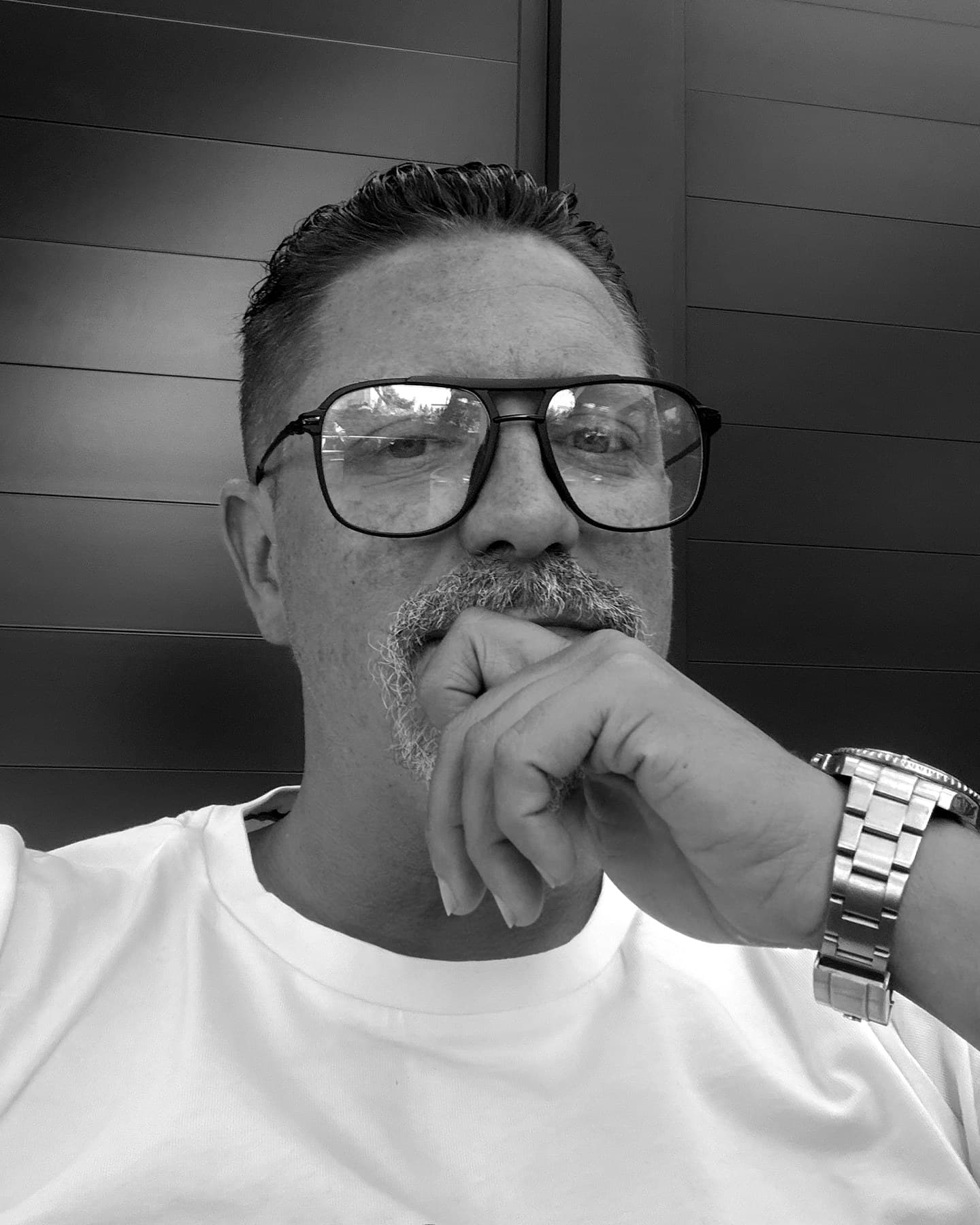 Michael Kolar, die Hand am Kinn, blickt nachdenklich in die Kamera. Schwarz-Weiß-Aufnahme.